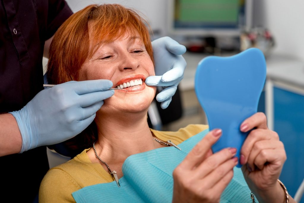 Woman checking her teeth at the mirror