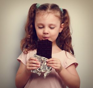 child eating a big bar of chocolate