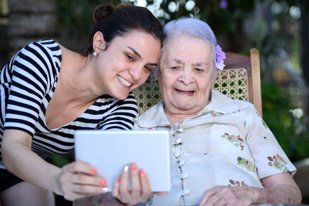 Woman video calling together with a senior