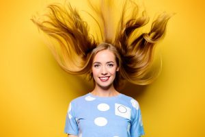 Woman with flying hair in yellow background