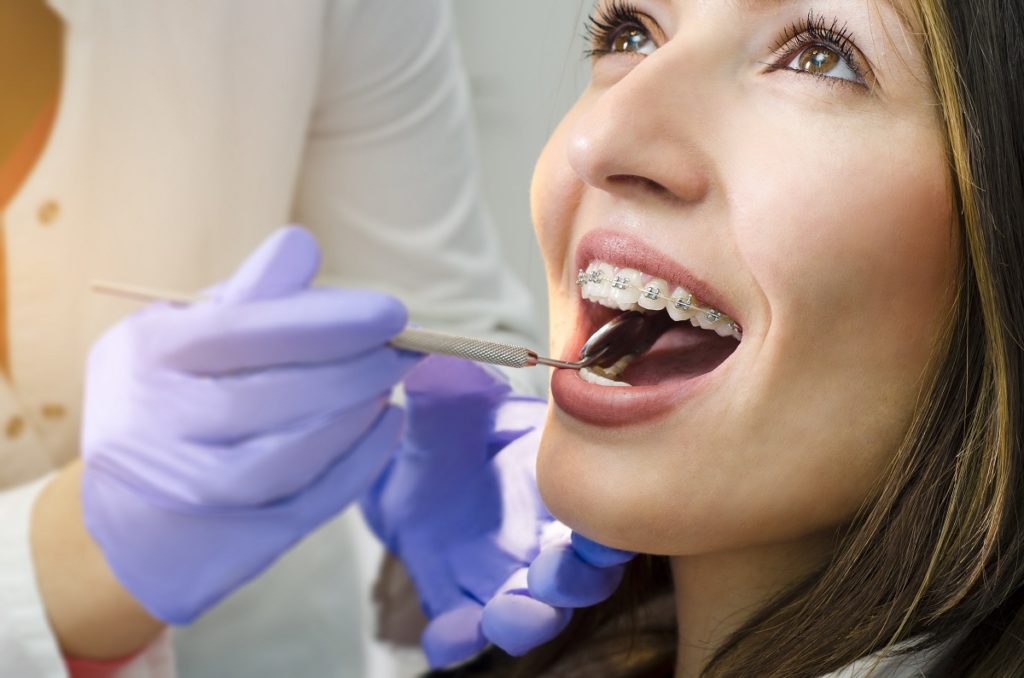 Woman in braces having her teeth checked