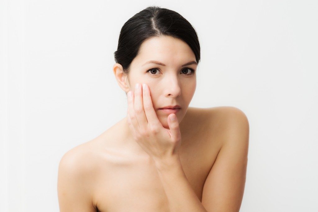 Woman touching her face