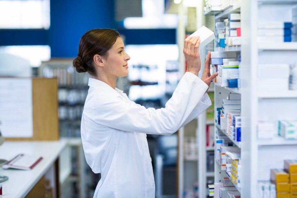 Pharmacist putting medicines on the rack