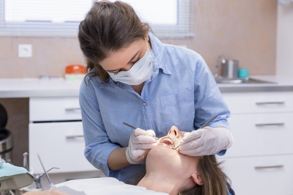 a dentist checking her patient's teeth