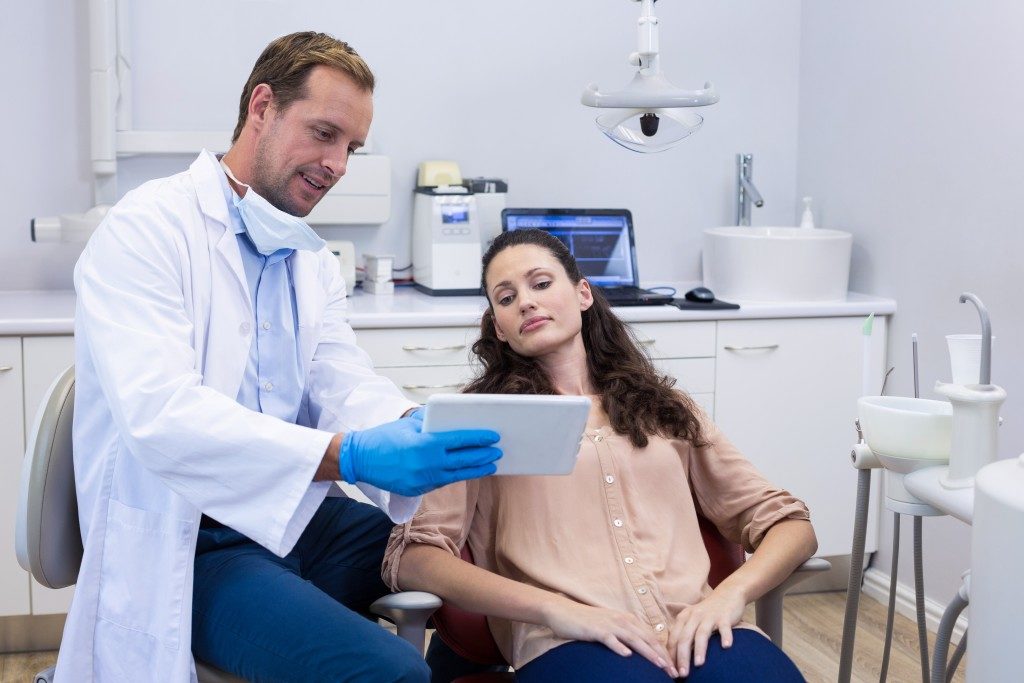 dentist showing dental assessment to patient