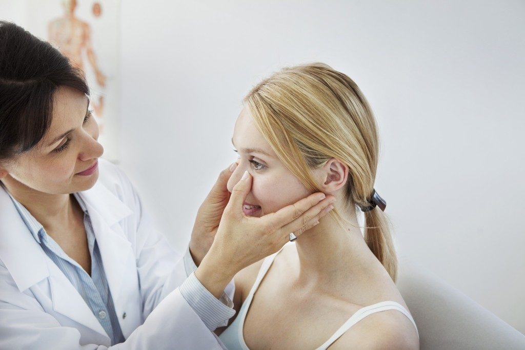 doctor checking the nose of a woman