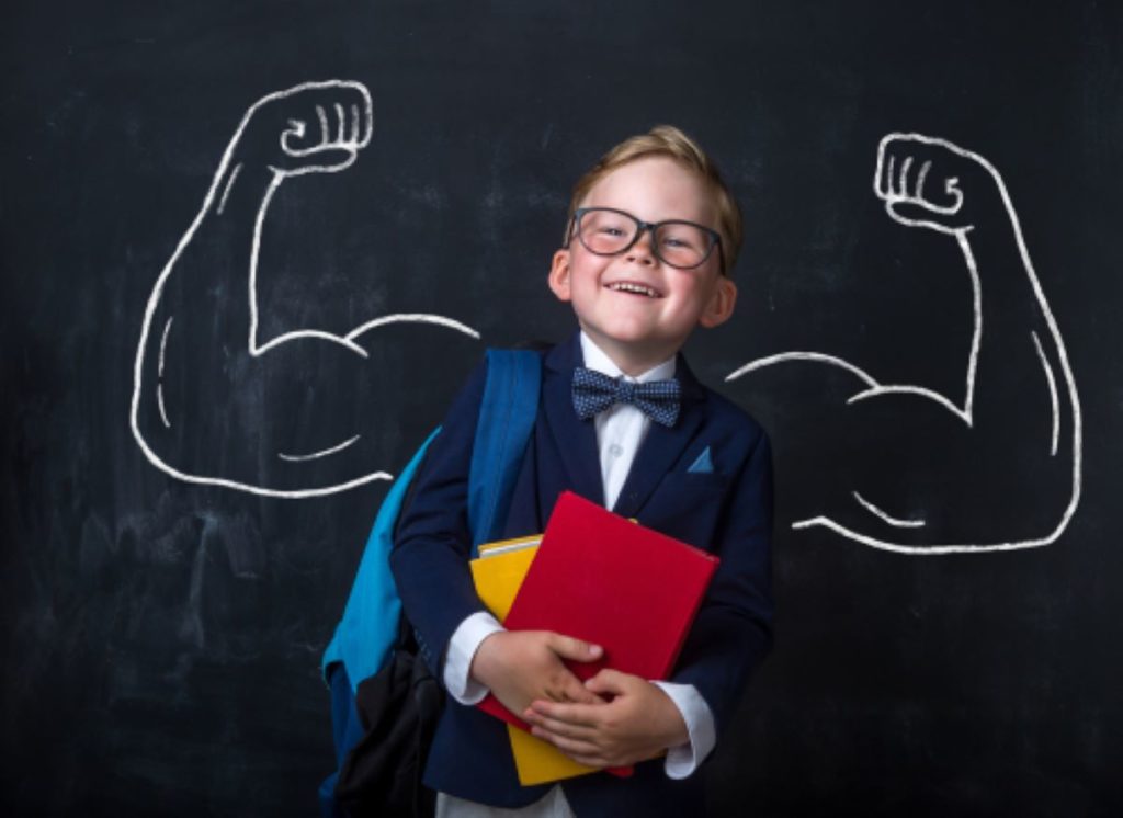 child with muscular biceps drawn behind on a chalk board