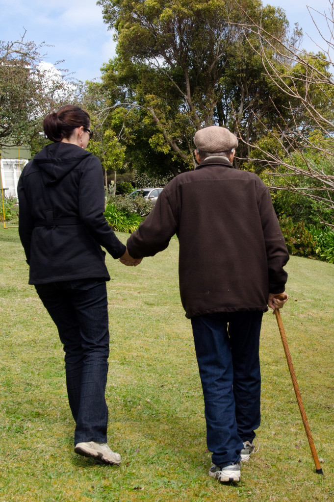 senior person being assisted by a younger woman in walking
