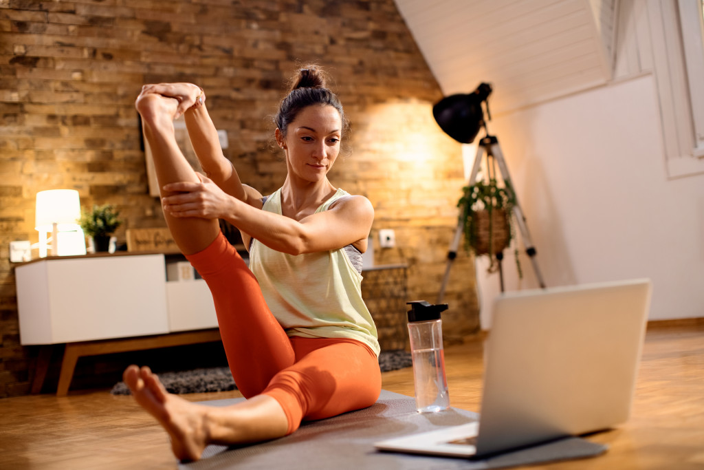 Athletic woman following online training on yoga 