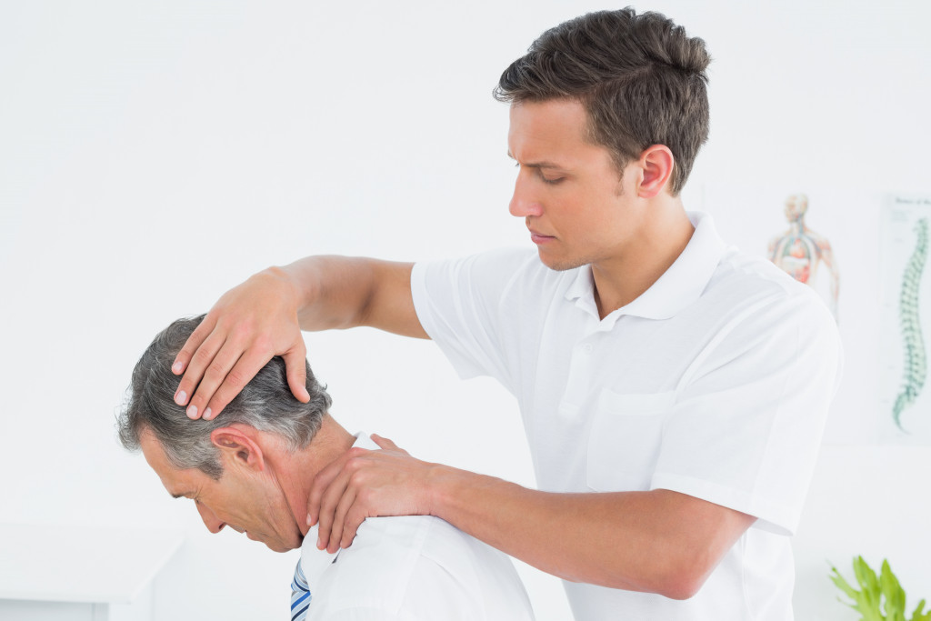 a male chiropractor doing neck adjustment on a male patient