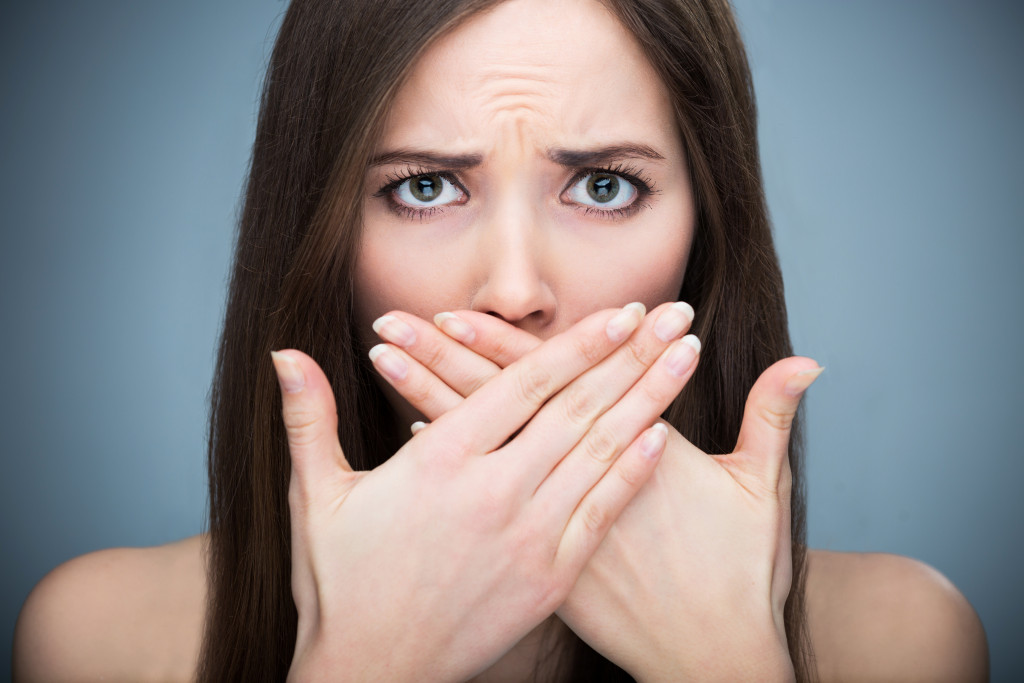 A young woman covering her mouth