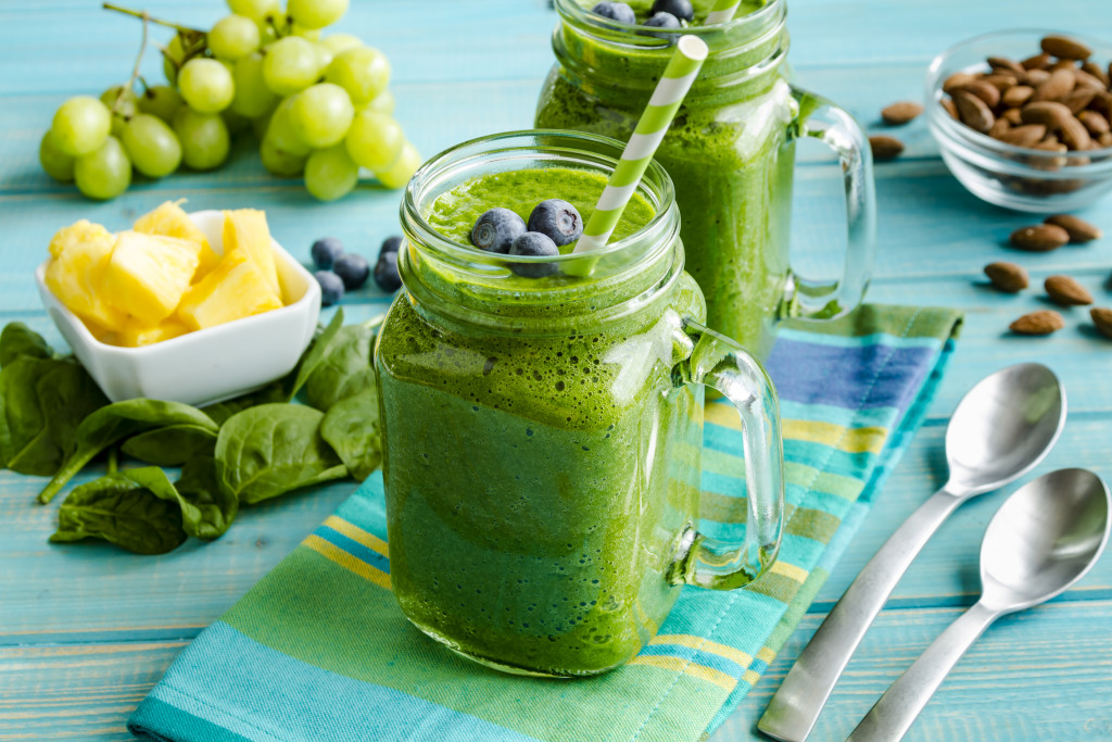 A mason jar mugs filled with a healthy spinach and kale smoothie