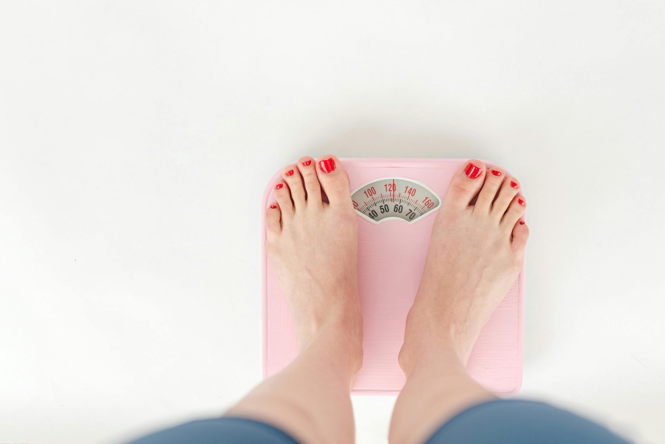 feet with red nails on a weighing scale